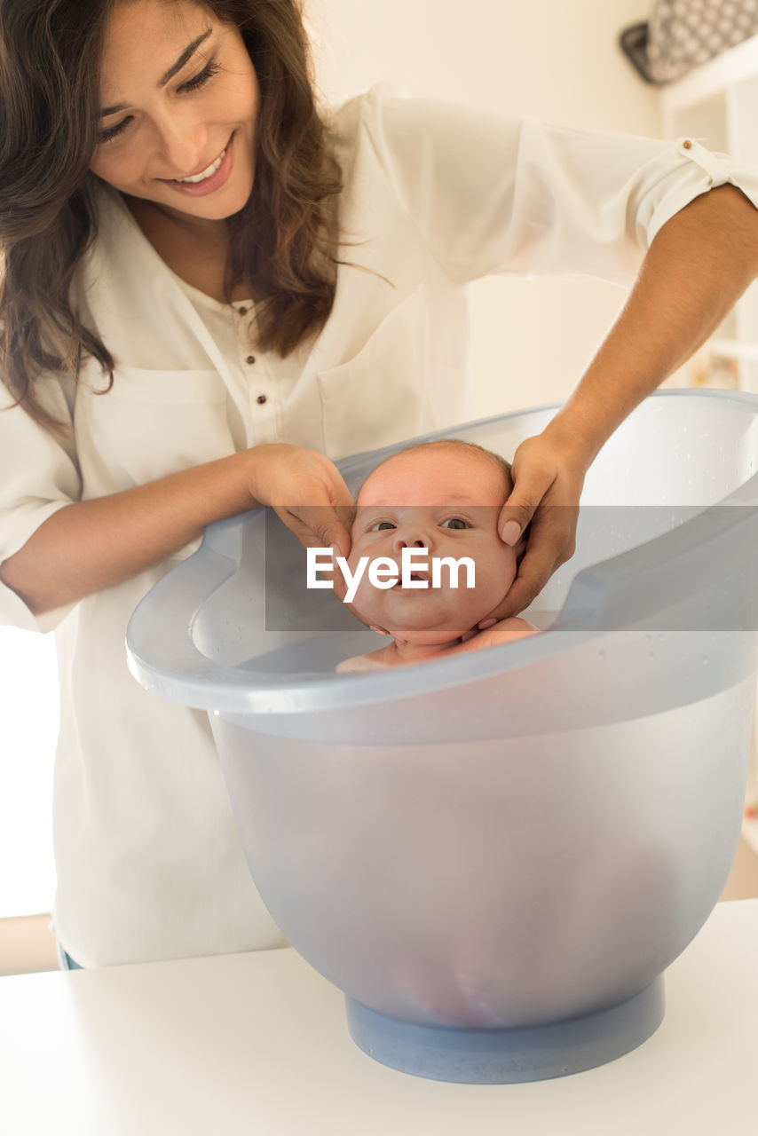 Mother bathing son in bathtub at bathroom