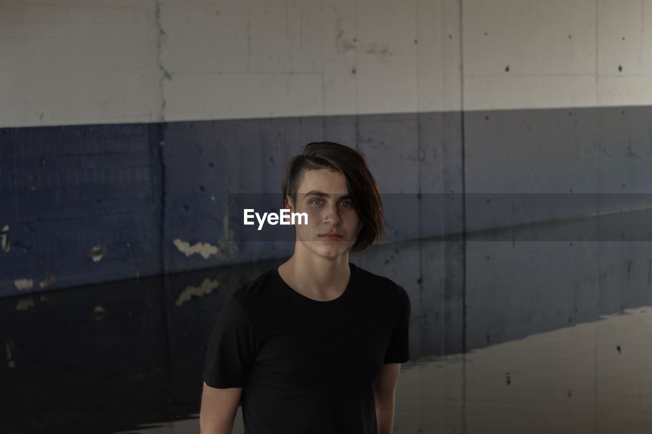 Portrait of man standing against wall