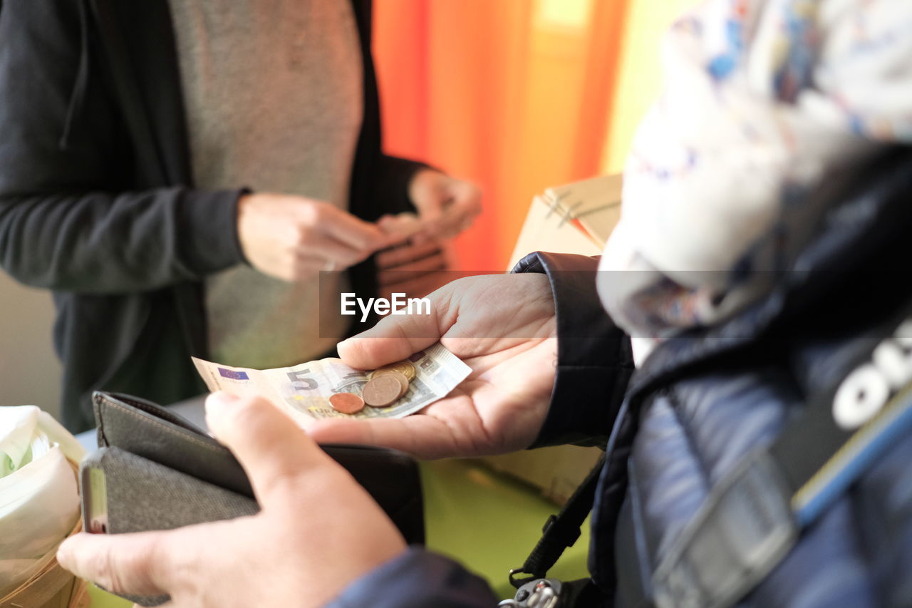 Midsection of person holding currency