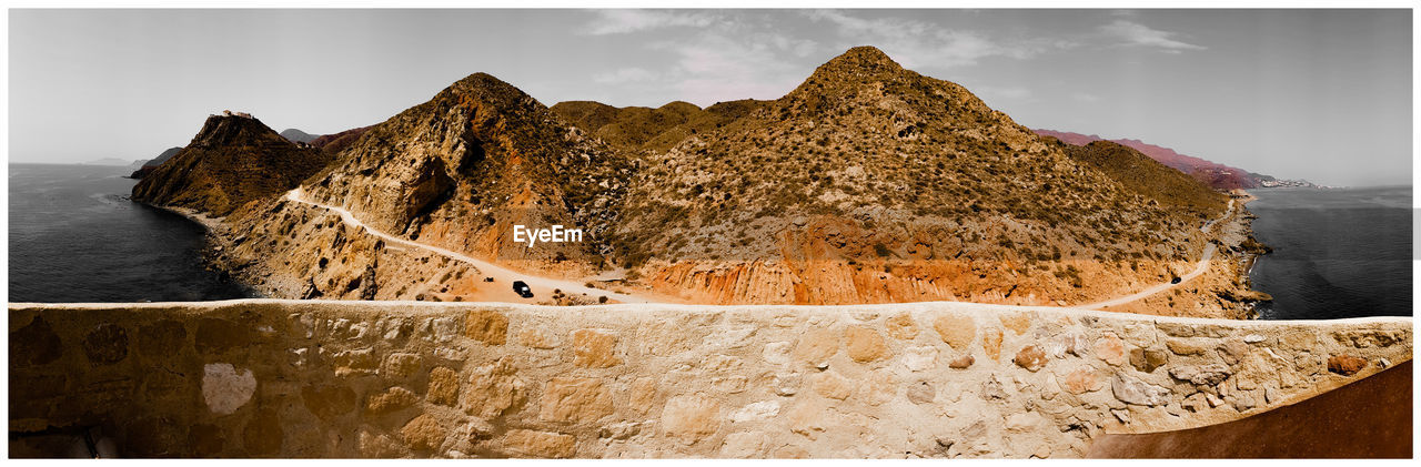 PANORAMIC VIEW OF ROCKS ON SHORE AGAINST SKY