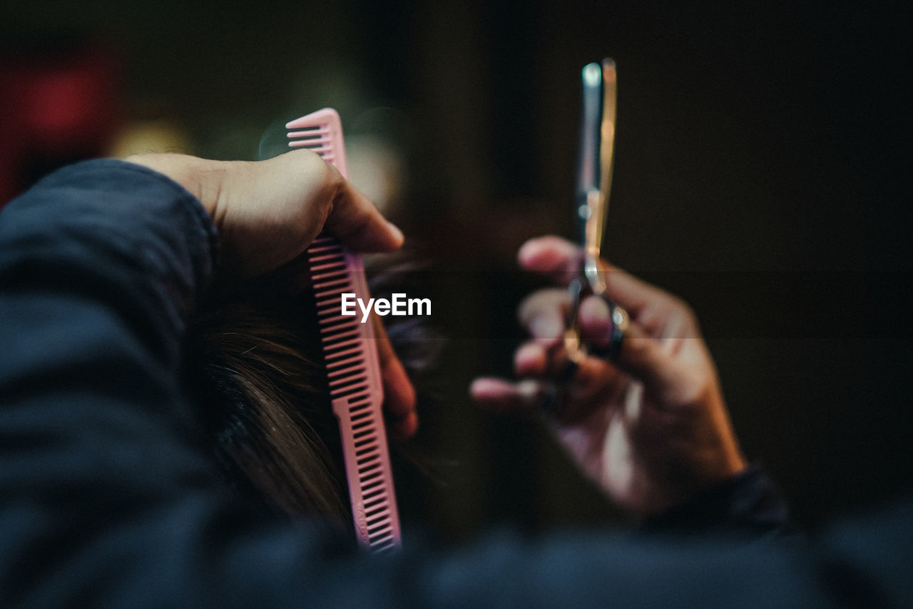 Hairdresser cutting customer hair in salon