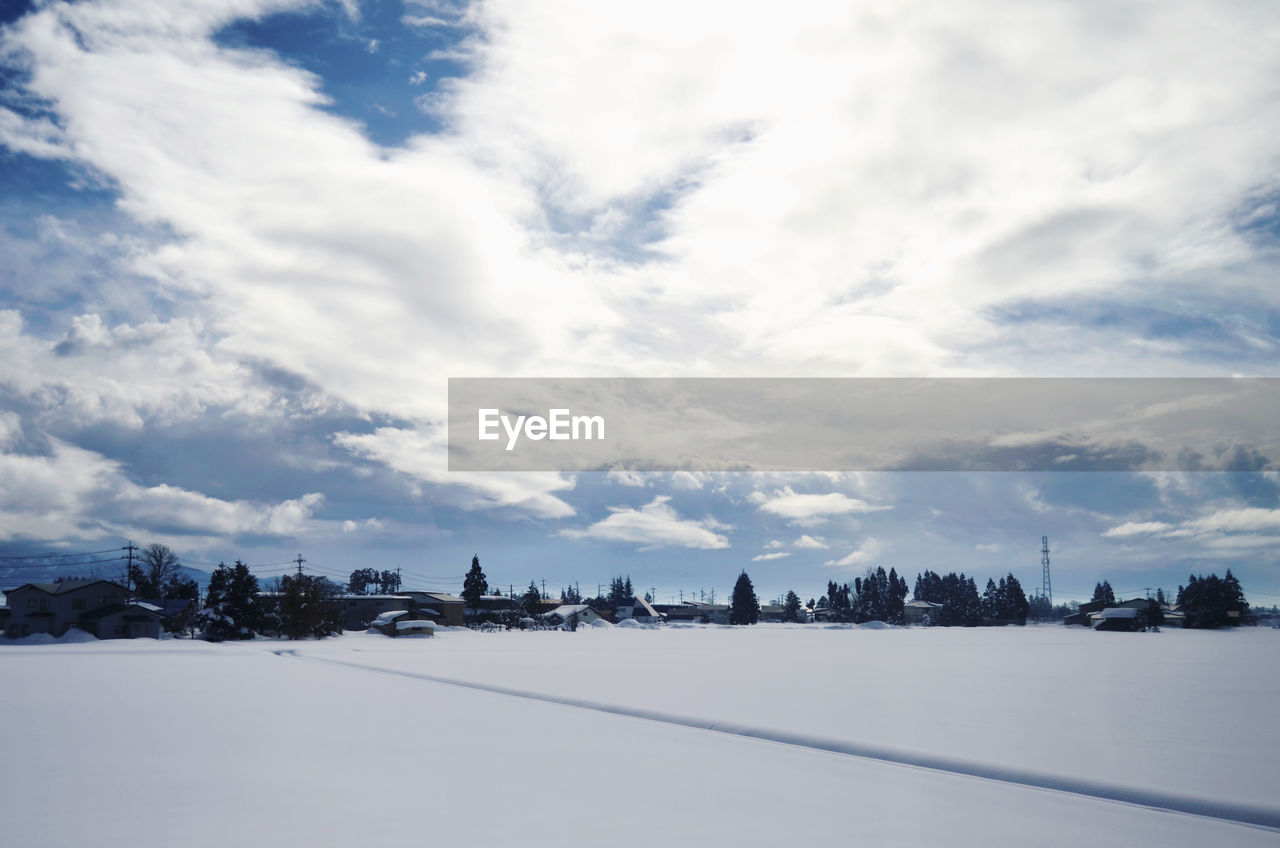 Snow covered city against sky