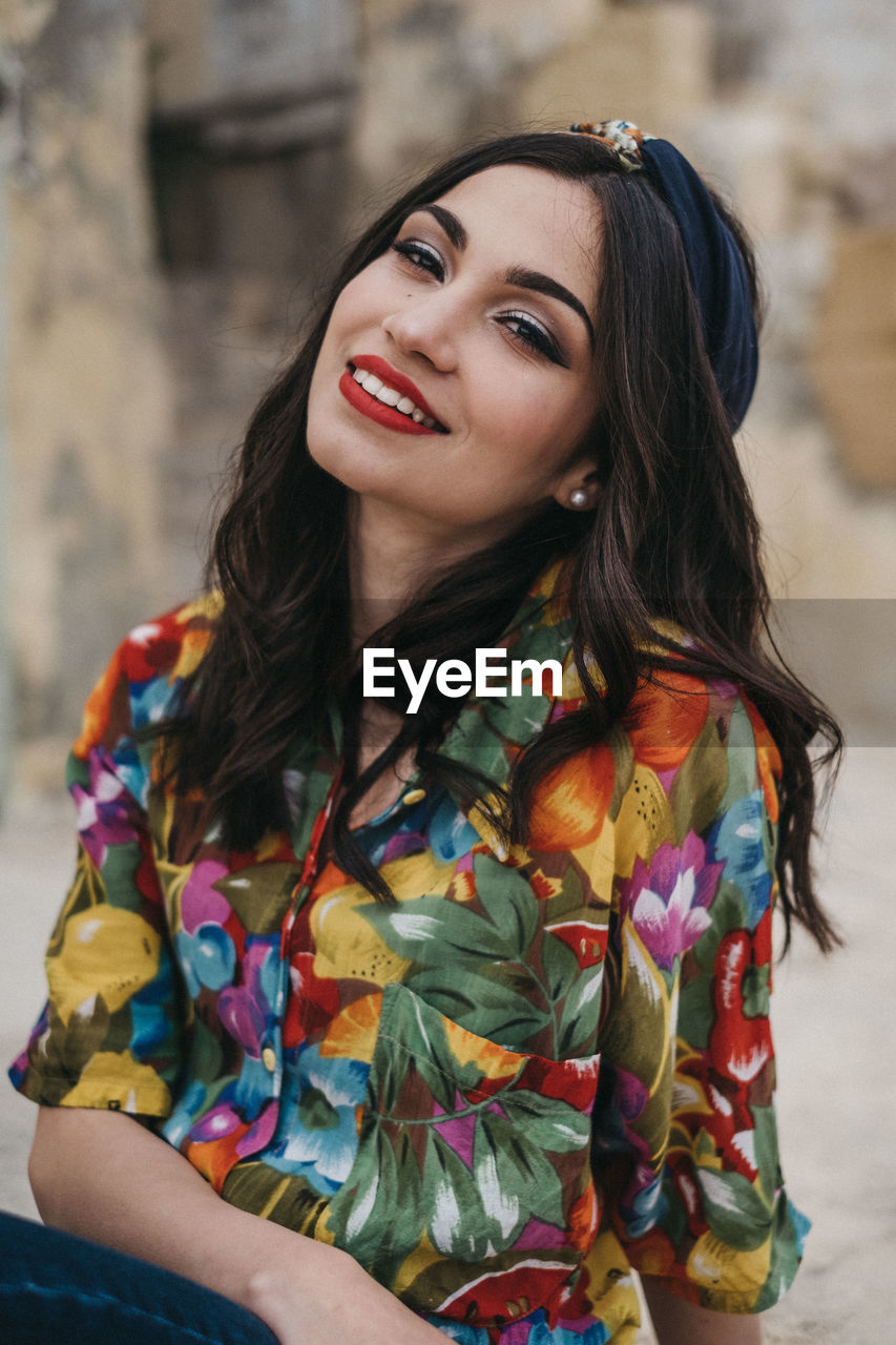 PORTRAIT OF A SMILING YOUNG WOMAN OUTDOORS