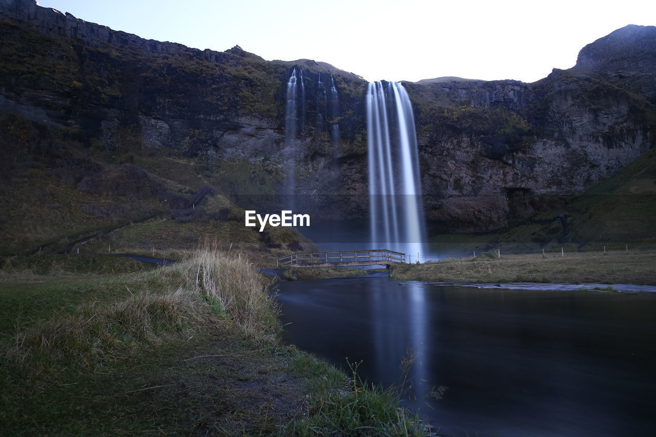 Scenic view of waterfall against sky