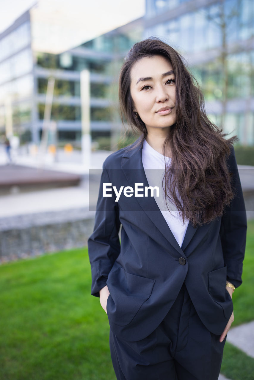 Relaxed asian confident business woman in suit smiling. job, work aspirational banner