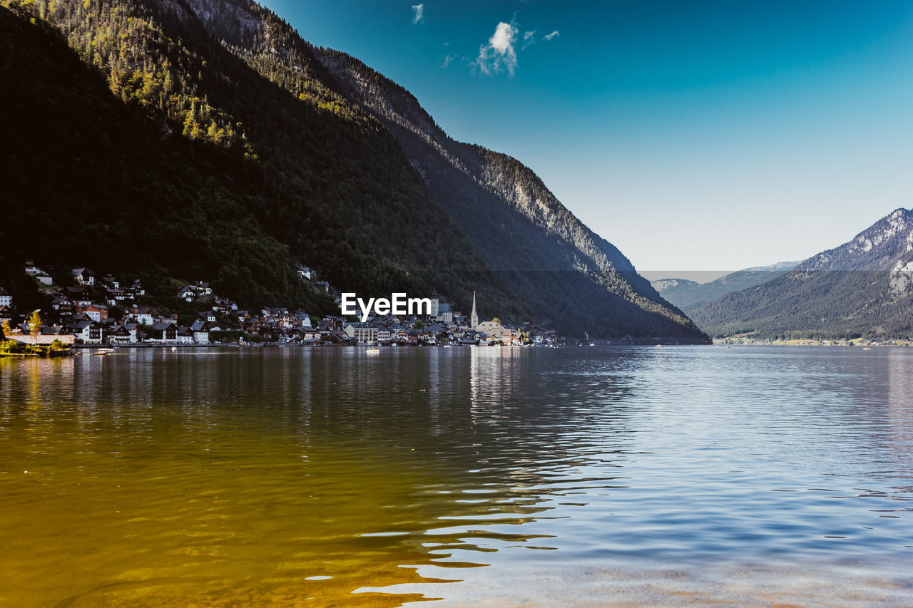 Scenic view of lake by mountains against sky