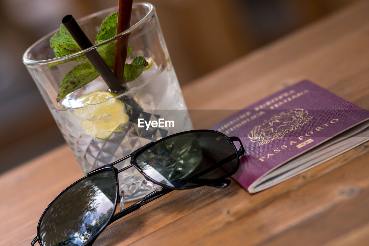 Summer vacation concept. mojito, a traditional cuban highball, italian passport and sunglasses