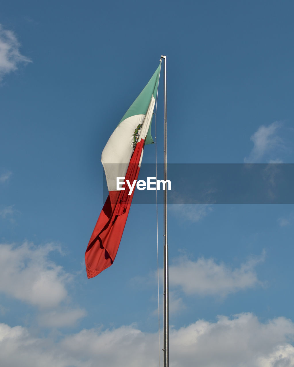 Low angle view of flag waving against sky