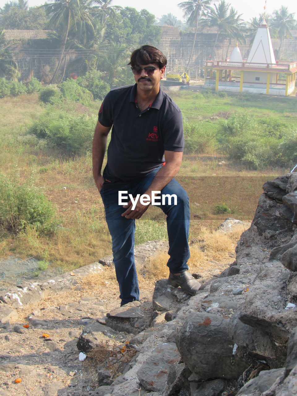 YOUNG MAN STANDING ON ROCK