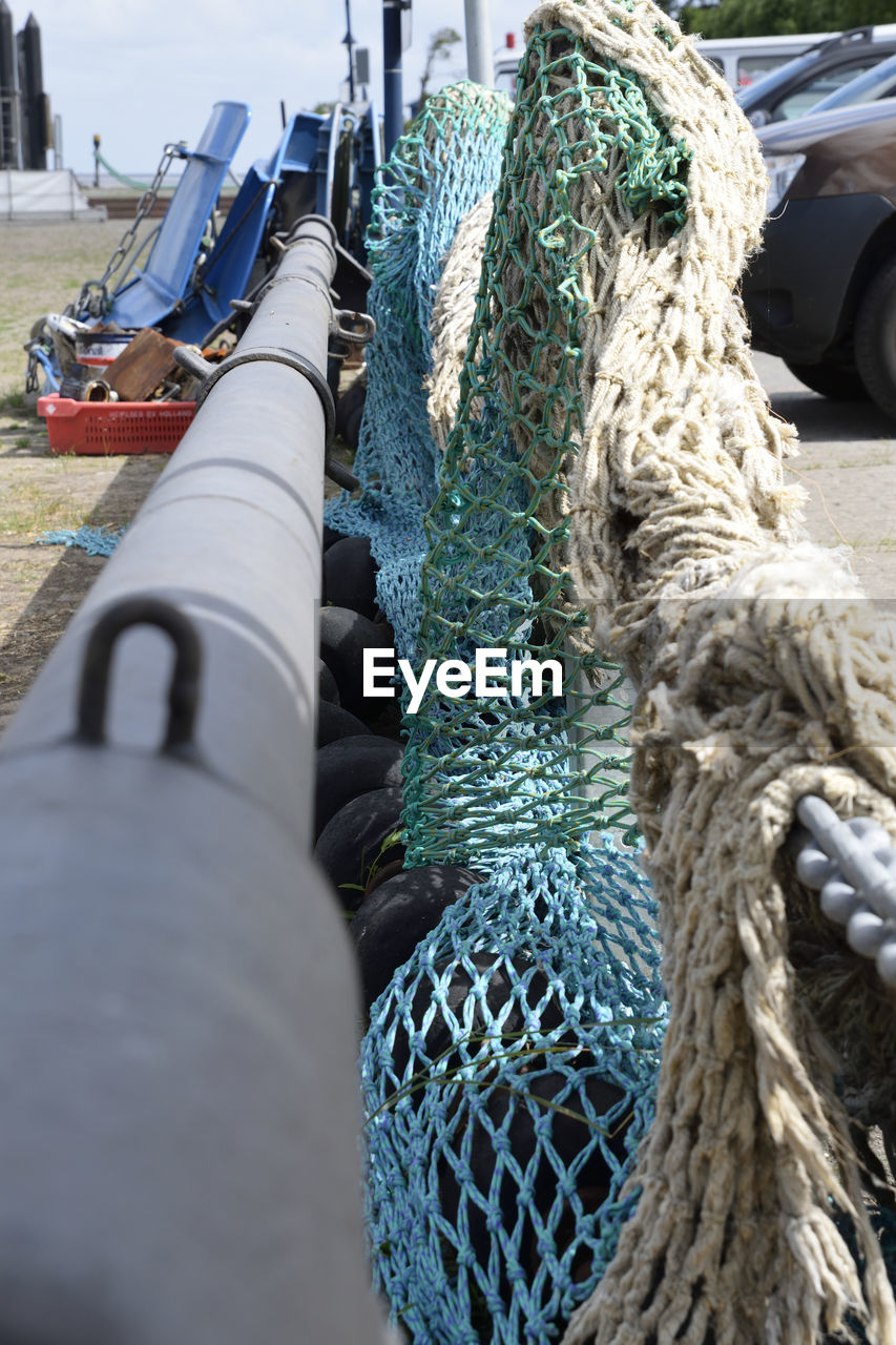 CLOSE-UP OF FISHING NET AGAINST BOATS
