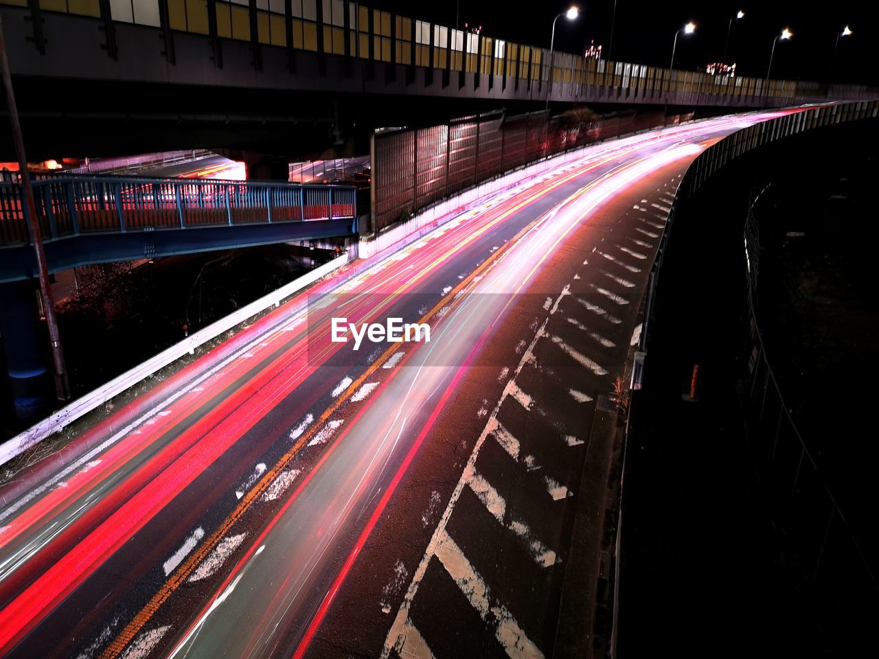 light trail, transportation, long exposure, motion, speed, night, illuminated, road, architecture, traffic, city, tail light, street, blurred motion, mode of transportation, built structure, highway, light, no people, city life, darkness, red, motor vehicle, building exterior, car, lighting equipment, outdoors, city street, street light, on the move, light - natural phenomenon, lane, bridge, high angle view, sign, infrastructure, land vehicle, travel destinations, headlight