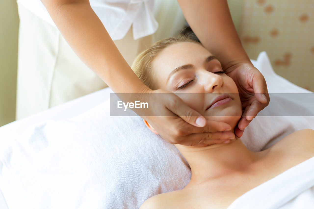 Young woman getting massage while lying down at beauty spa