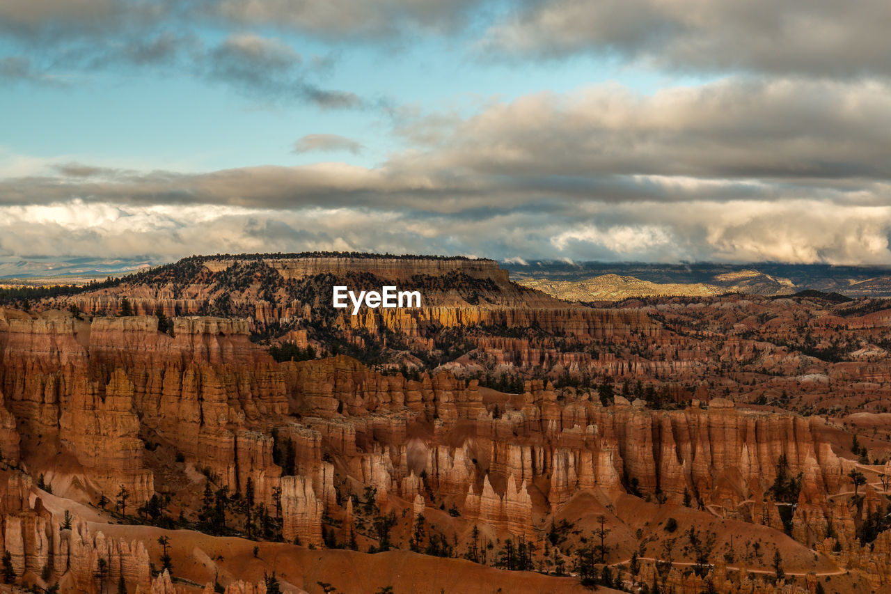 Panoramic view of rocky mountains against cloudy sky