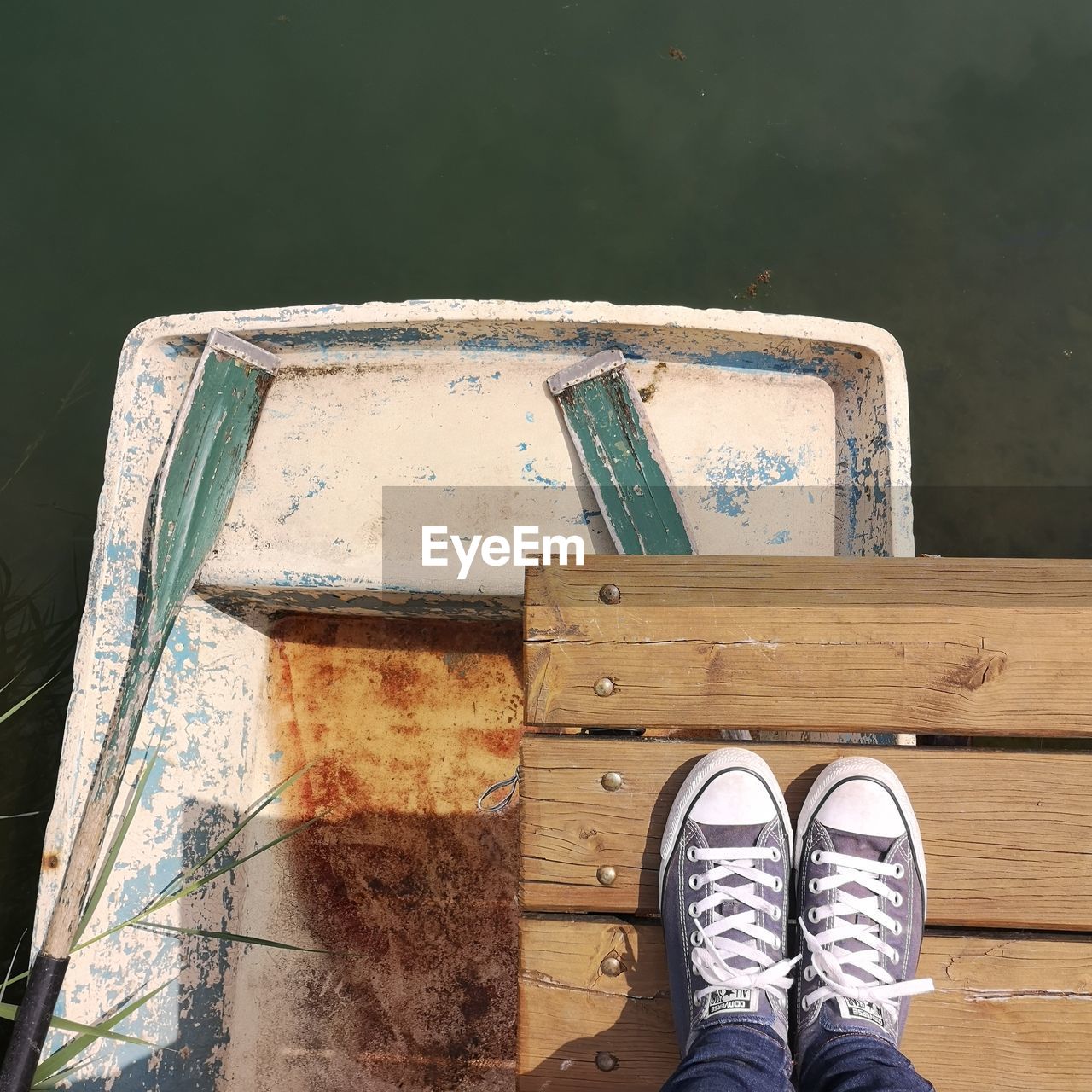 LOW SECTION OF PERSON WITH TEXT ON WOOD AGAINST SKY