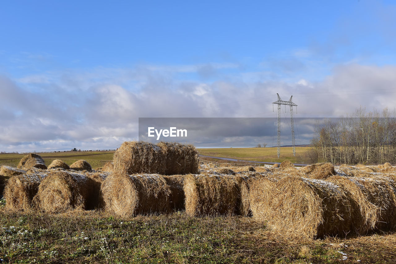 HAY BALES ON FIELD AGAINST SKY DURING SUNSET