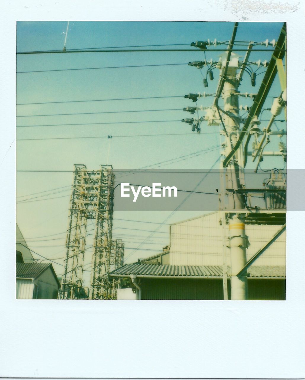 Low angle view of electricity pylon in town against sky