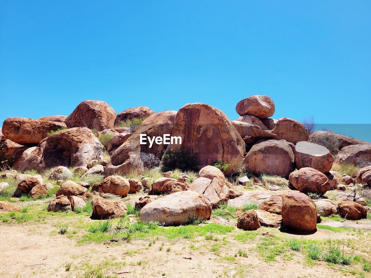 VIEW OF ROCKS ON LAND AGAINST CLEAR BLUE SKY