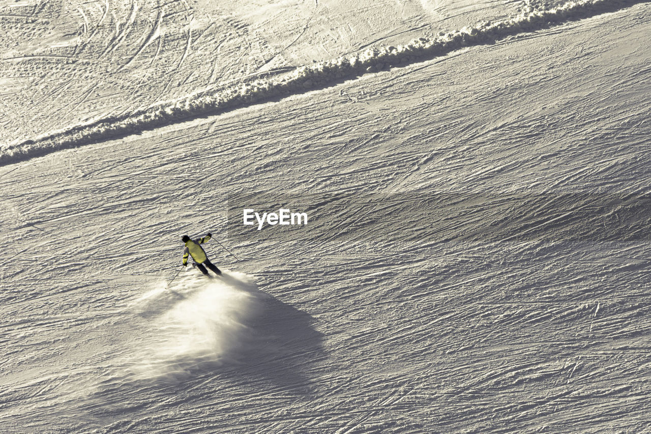 High angle view of people skiing on snow covered landscape