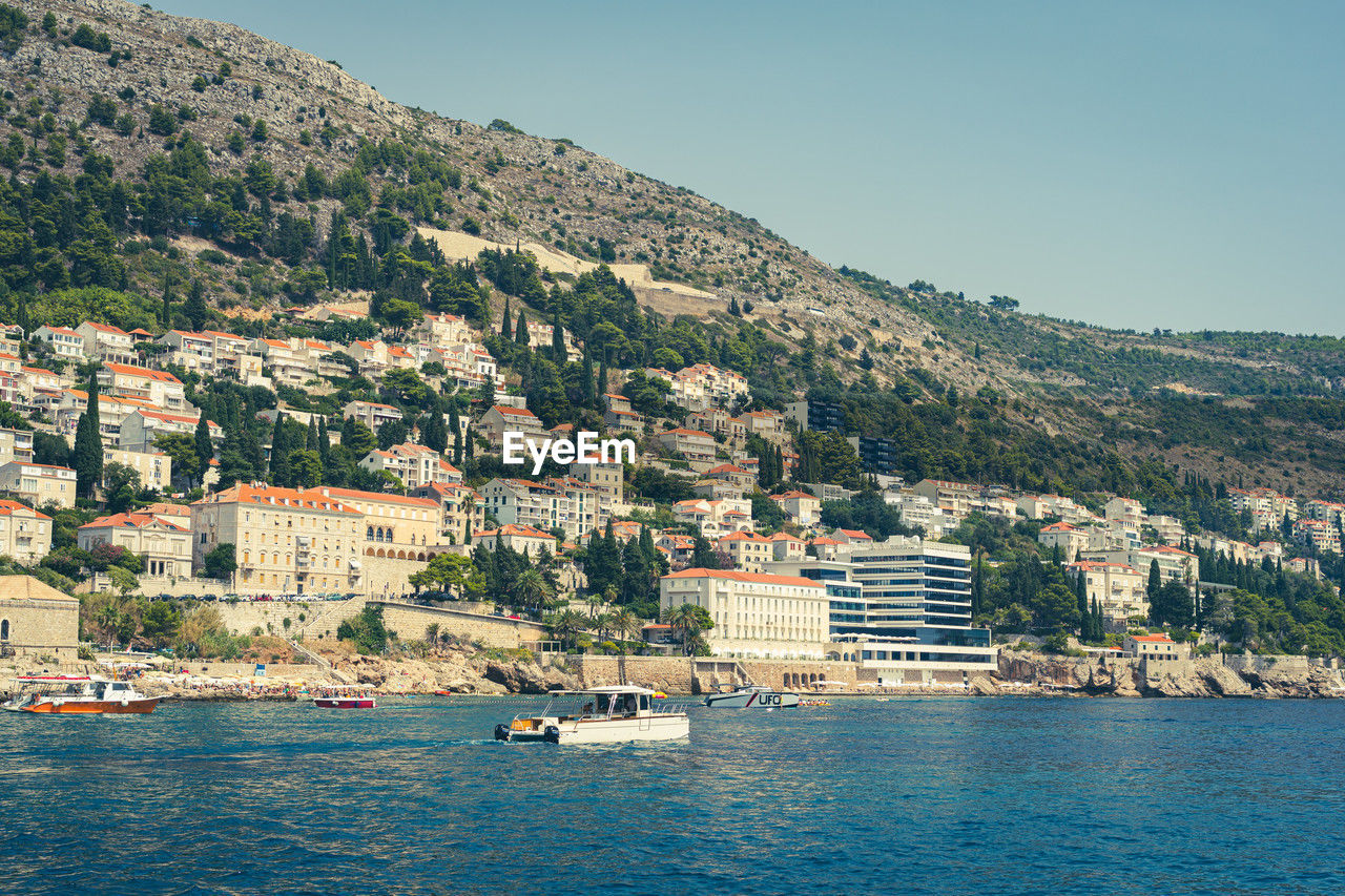 high angle view of townscape by sea against mountain