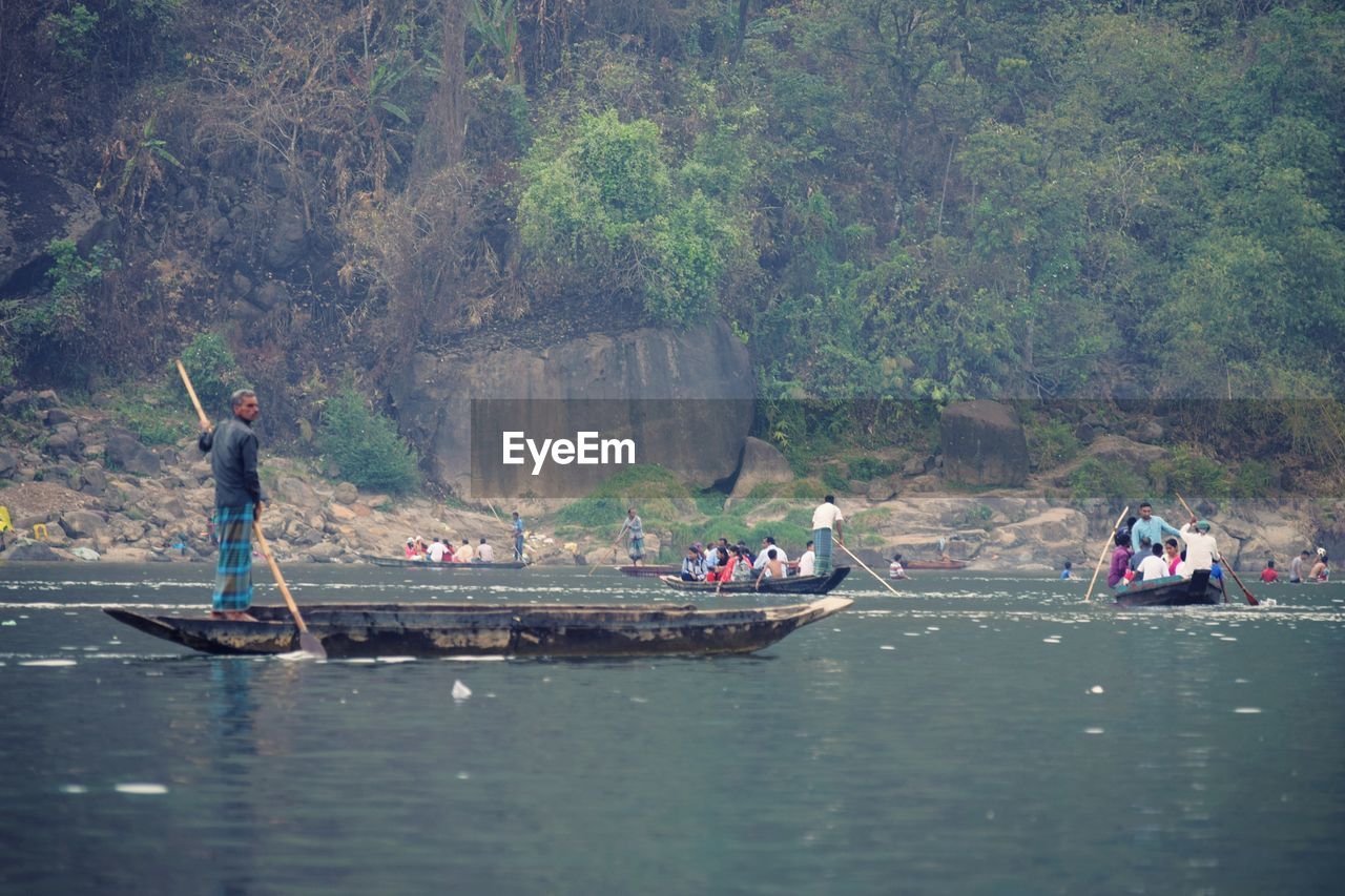 People on boats sailing in river