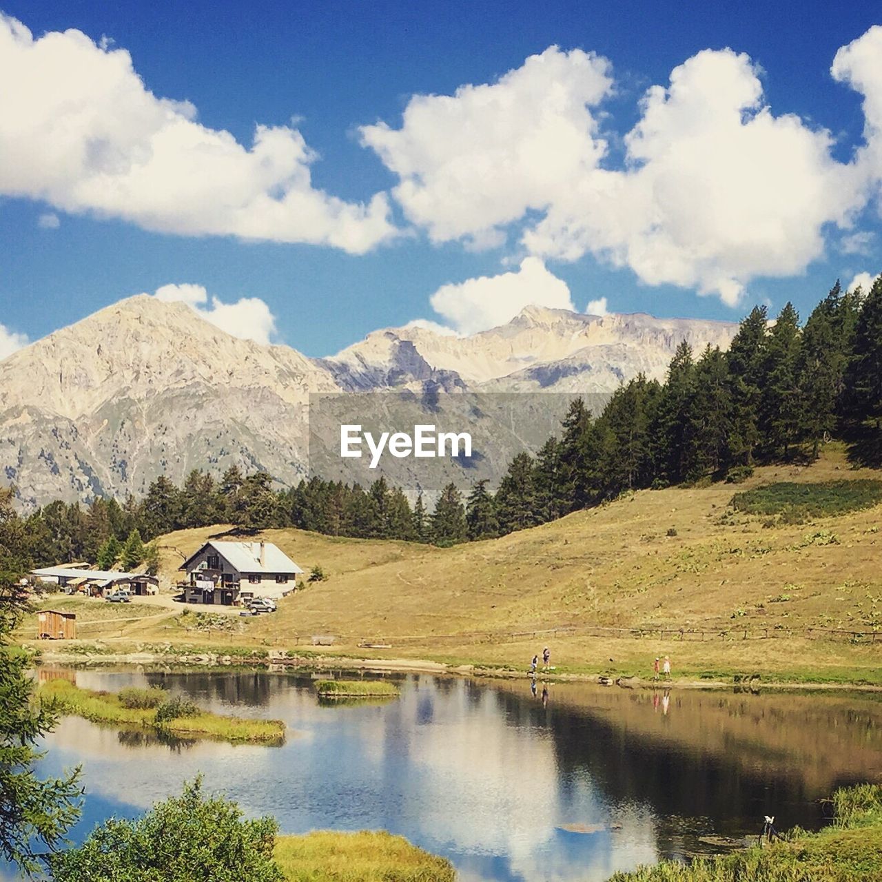 SCENIC VIEW OF LAKE AMIDST HOUSES AGAINST SKY