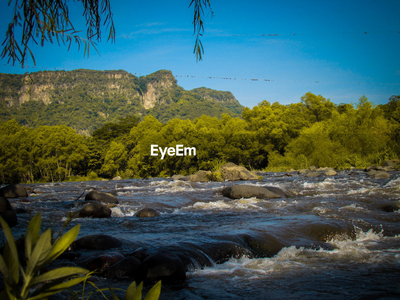 SCENIC VIEW OF RIVER FLOWING THROUGH ROCKS AGAINST SKY