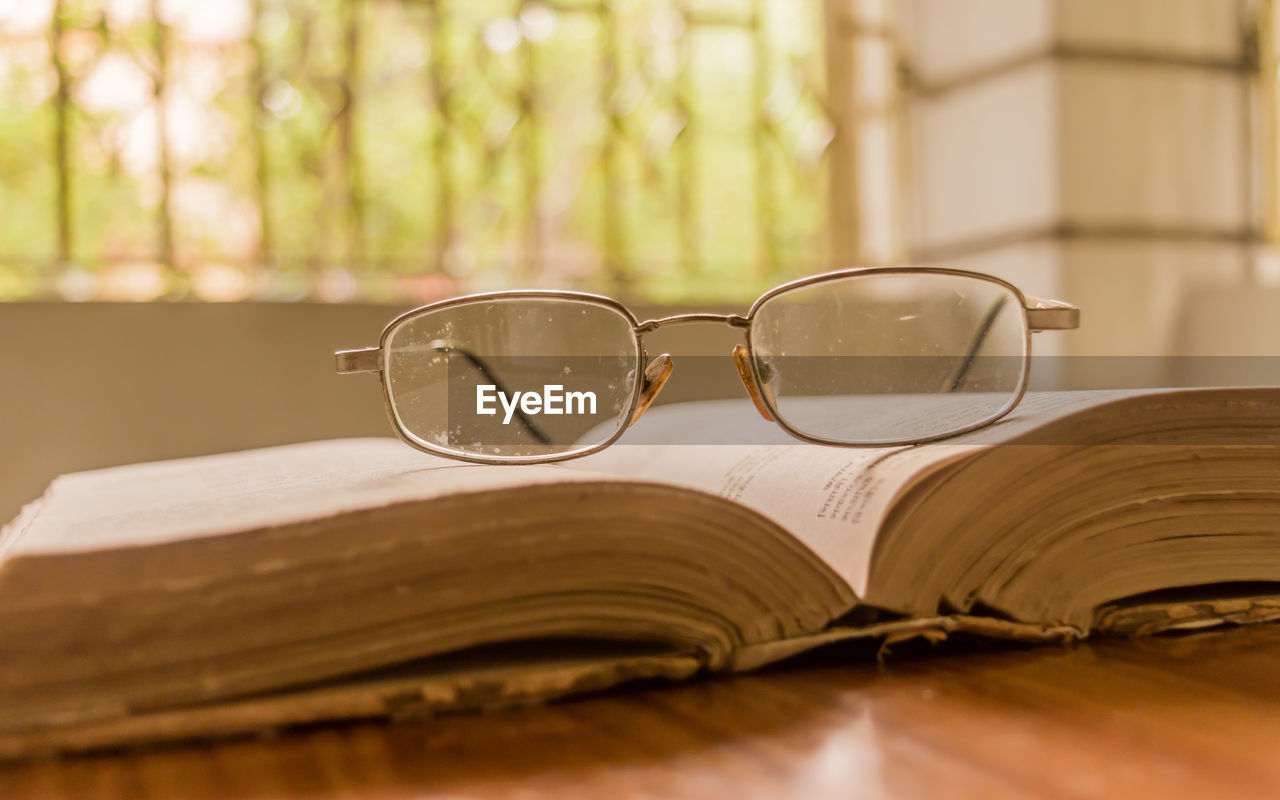 Close-up of eyeglasses on book on table