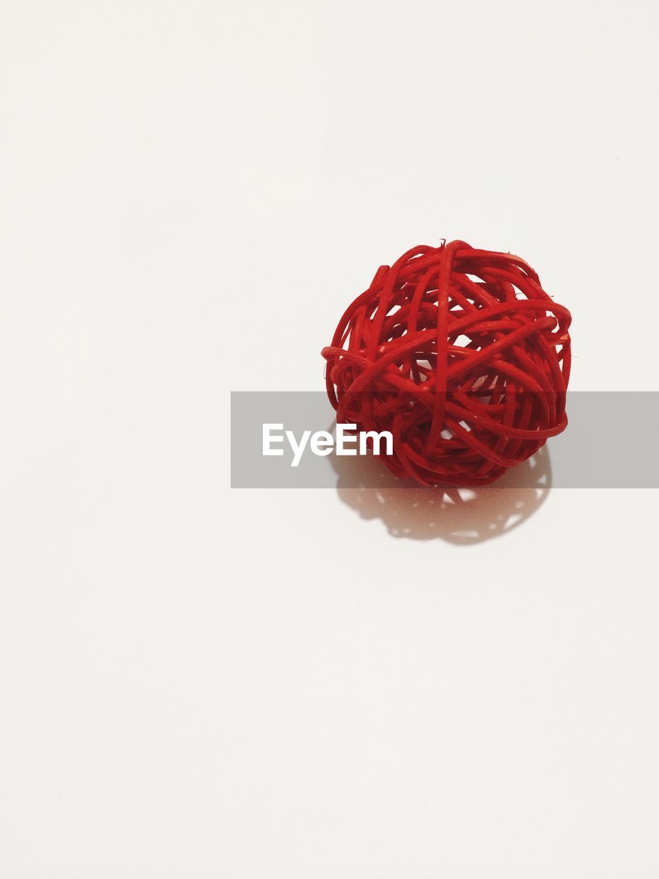 Red wicker ball over white background