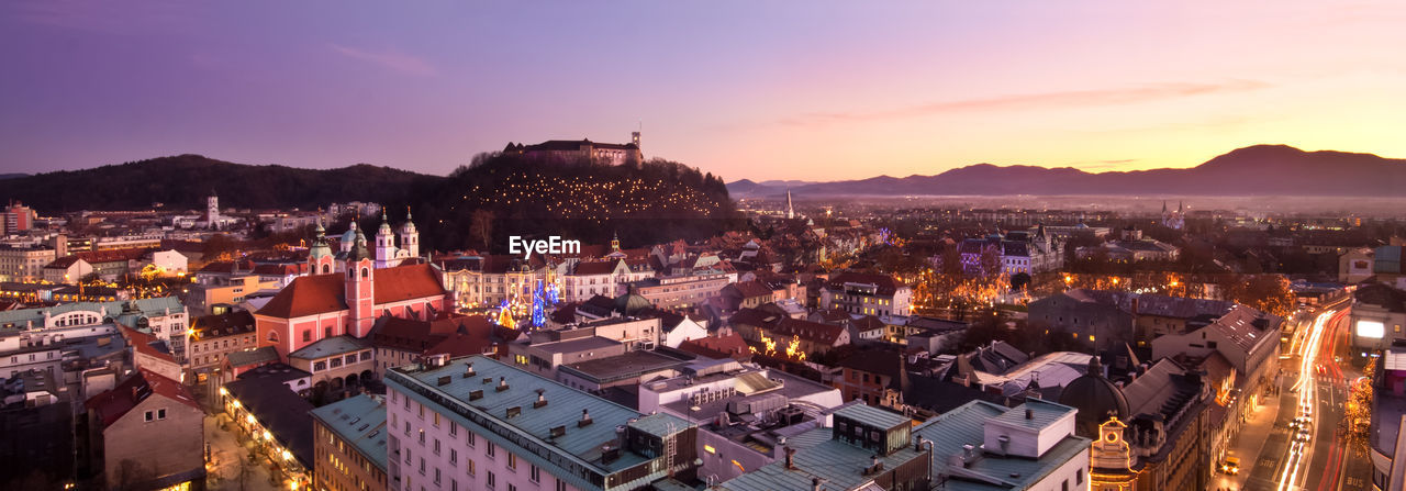 HIGH ANGLE VIEW OF ILLUMINATED CITYSCAPE AGAINST SKY