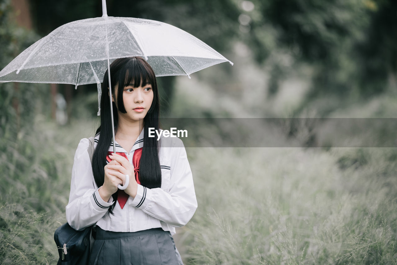 Portrait of beautiful woman standing in rain