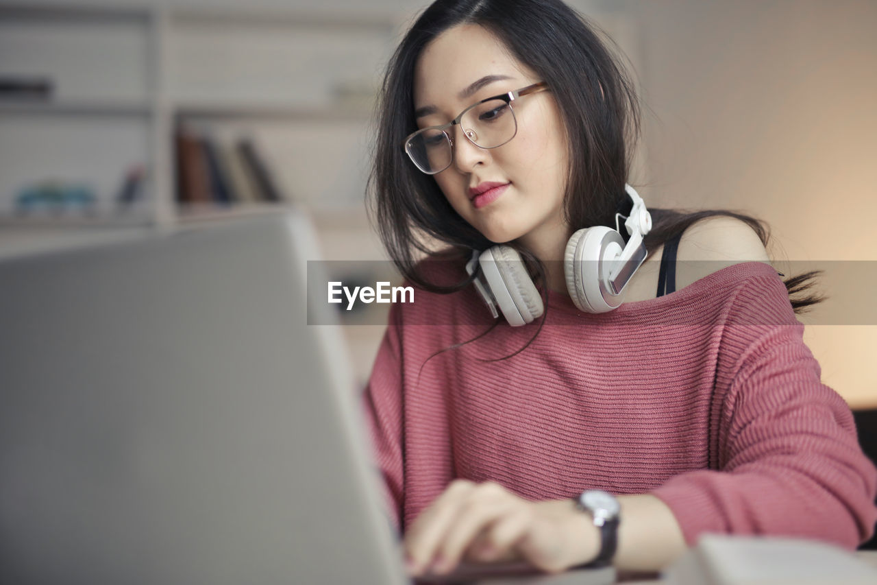 Young asian woman works with laptop