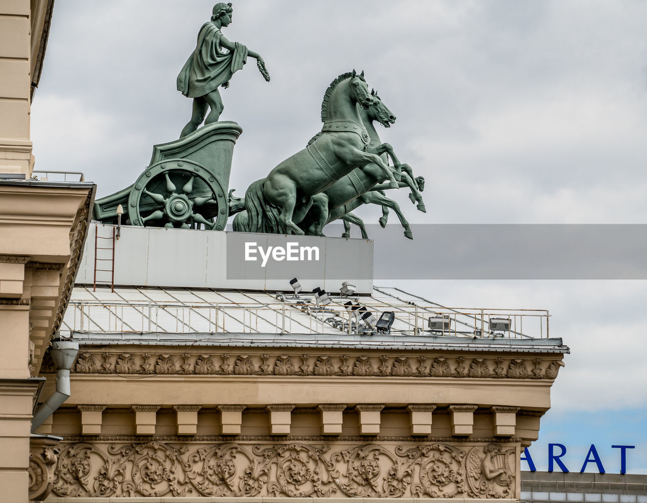 Low angle view of statue at bolshoi theatre against cloudy sky
