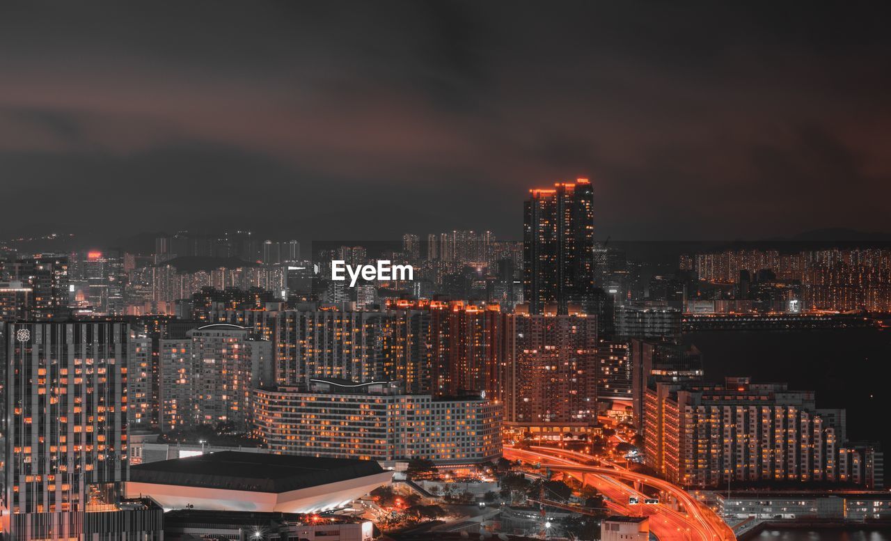 Illuminated cityscape against sky at night