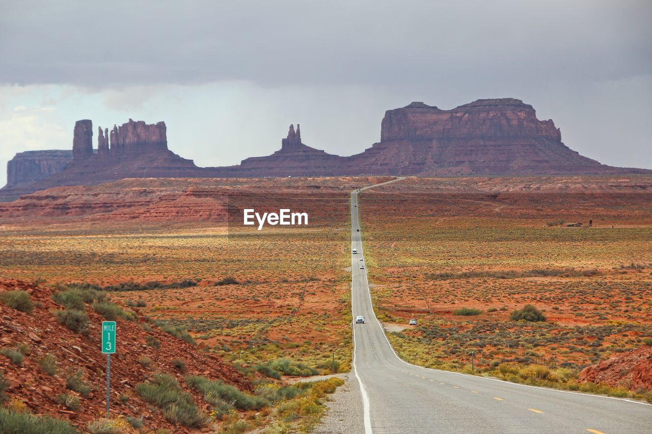 Road leading towards mountains against sky