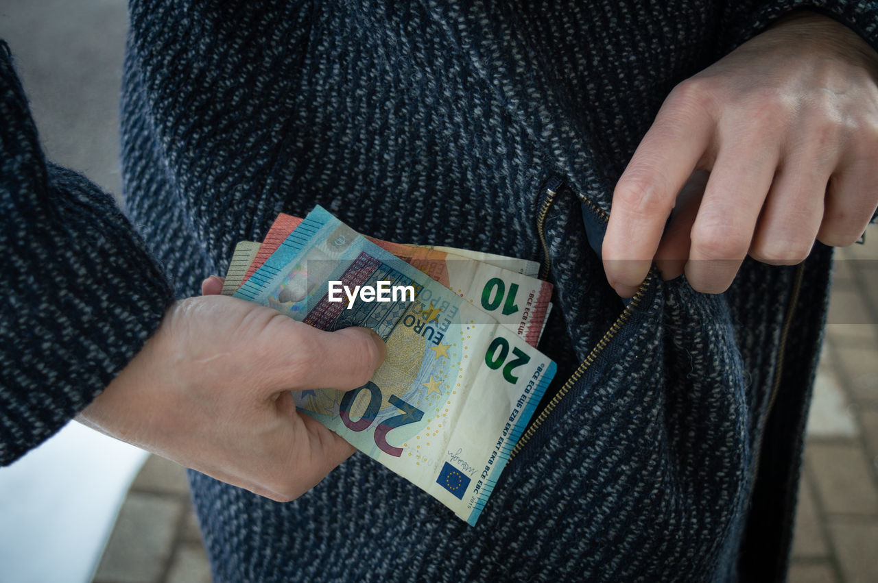 midsection of woman holding paper currencies