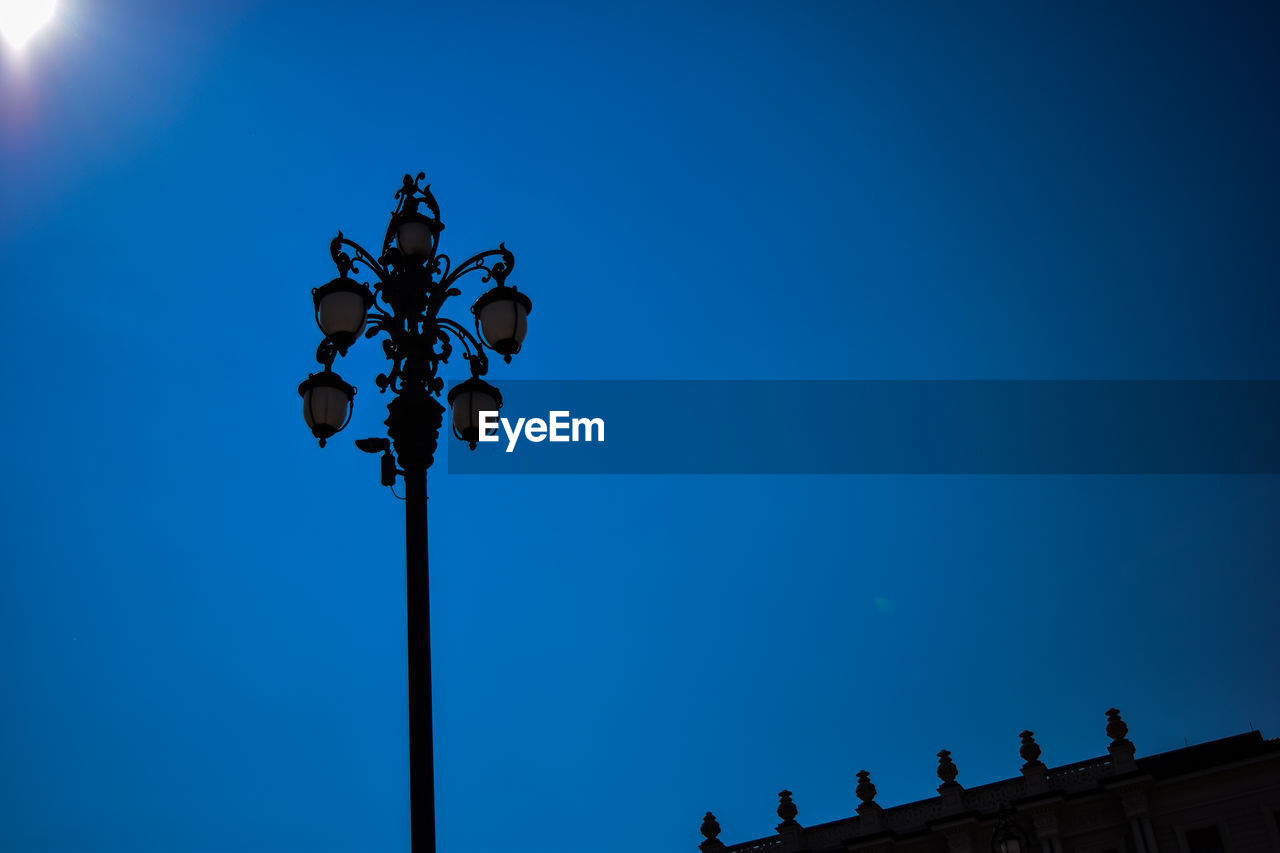 Low angle view of gas light against clear blue sky