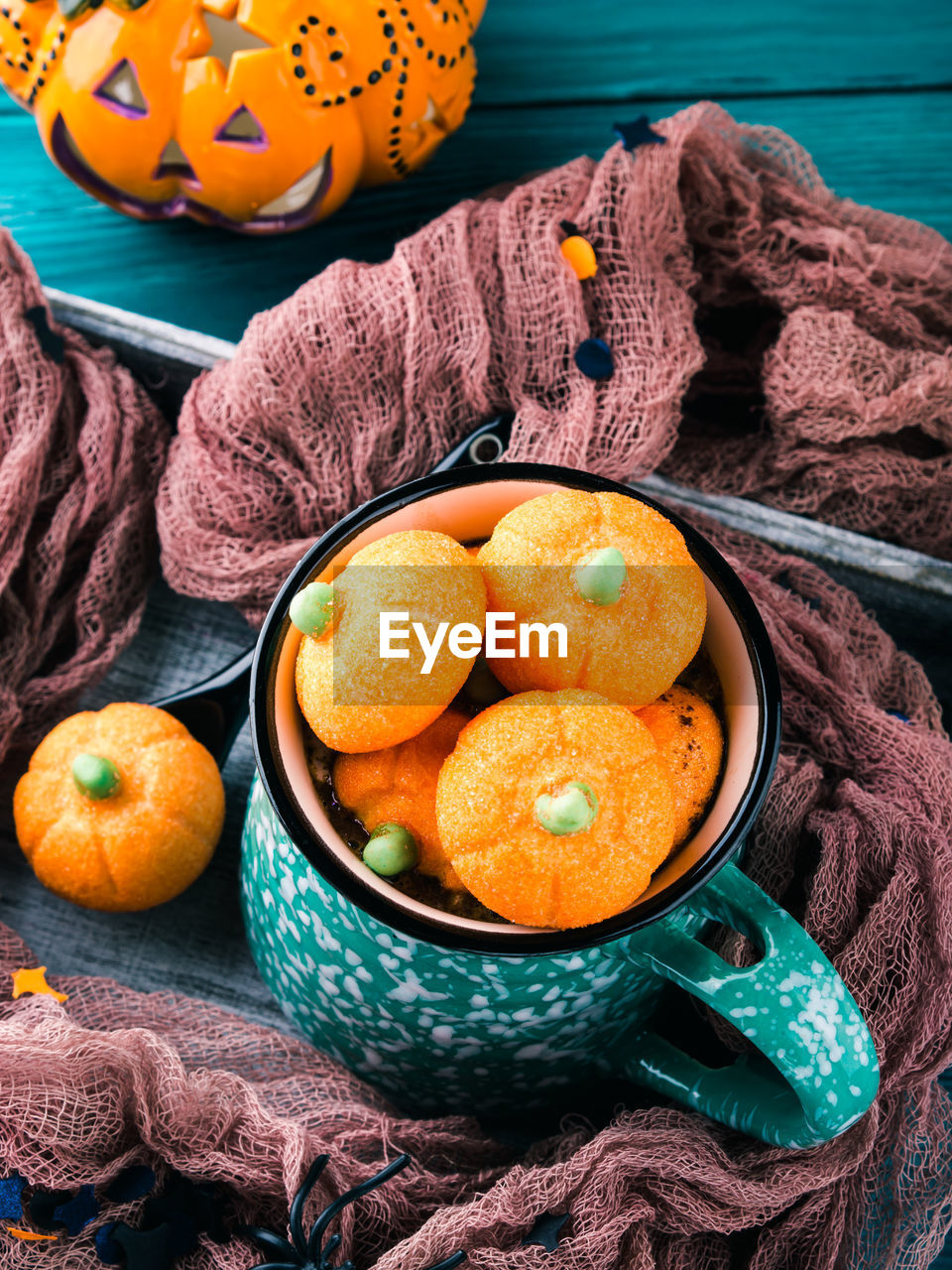 Hot cocoa with pumpkin marshmallows on dark styled halloween background