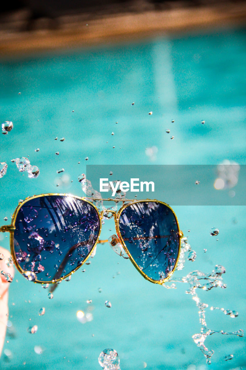 Close-up of water splashing on sunglasses