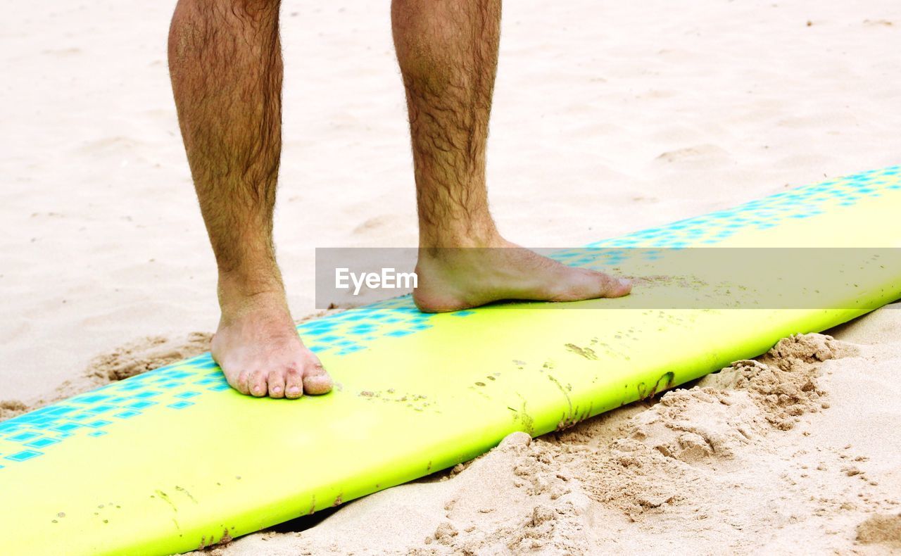 LOW SECTION OF MAN STANDING ON SAND