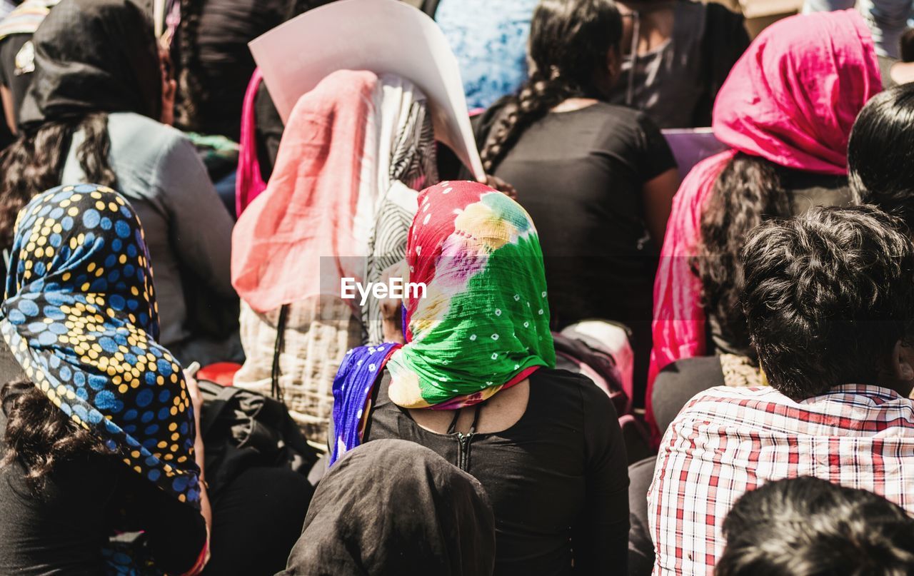 High angle rear view of crowd during social gathering in city on sunny day