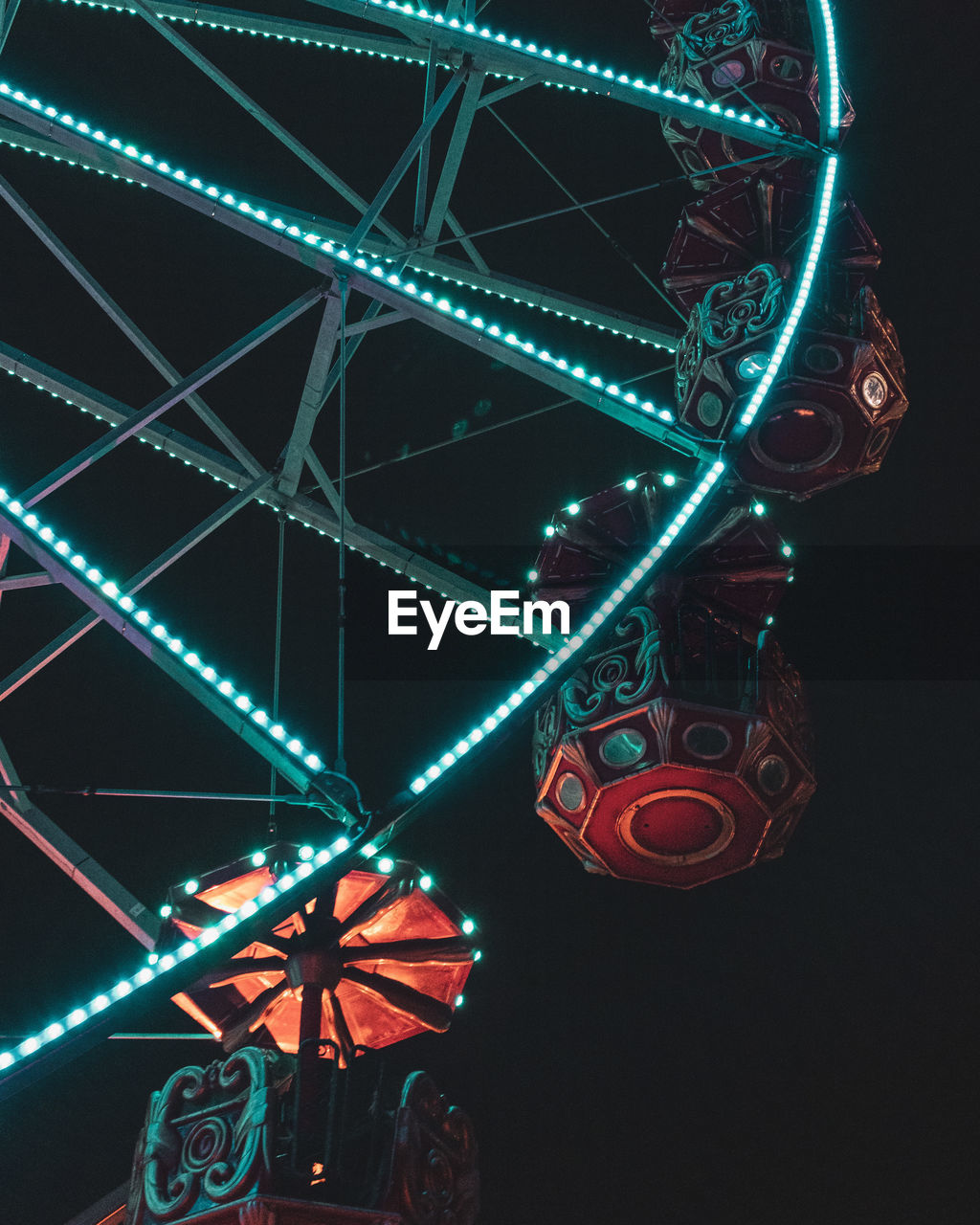 LOW ANGLE VIEW OF ILLUMINATED FERRIS WHEEL AGAINST CEILING