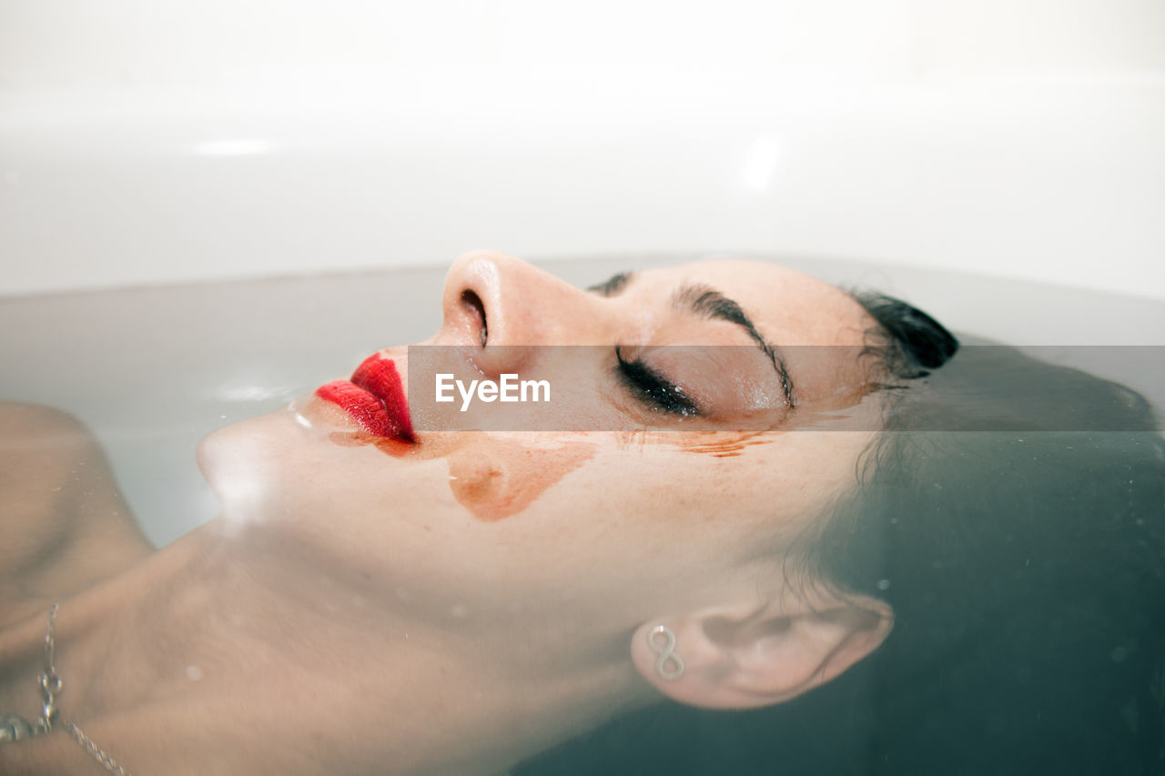 Midsection of woman with chocolate face in bathtub