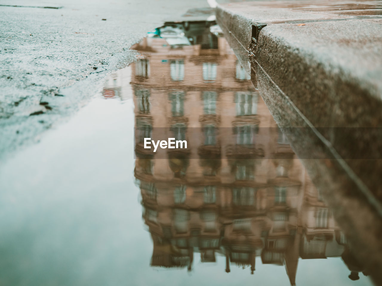 REFLECTION OF BUILDINGS IN PUDDLE ON CANAL