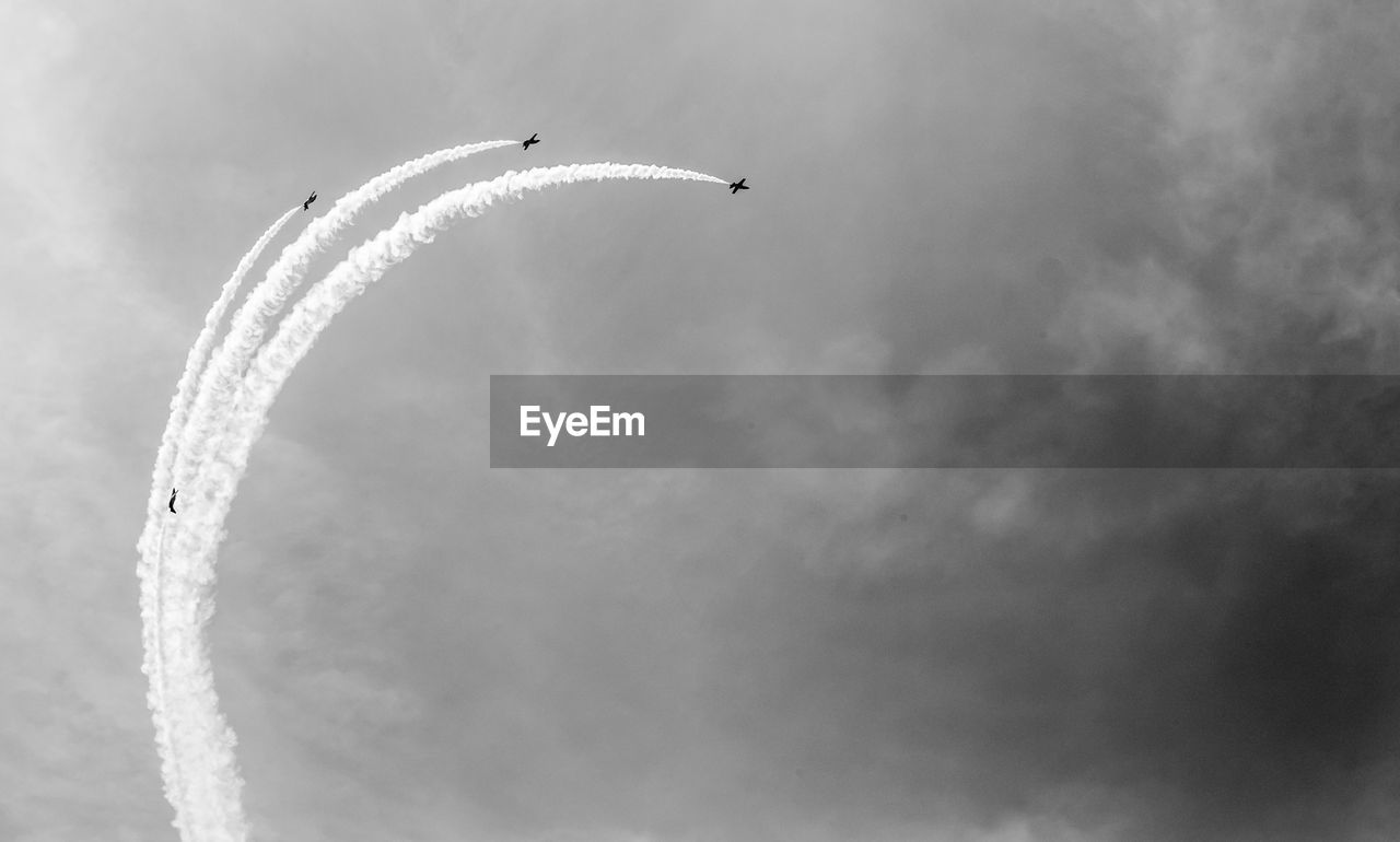 Low angle view of airplane flying against sky airshow