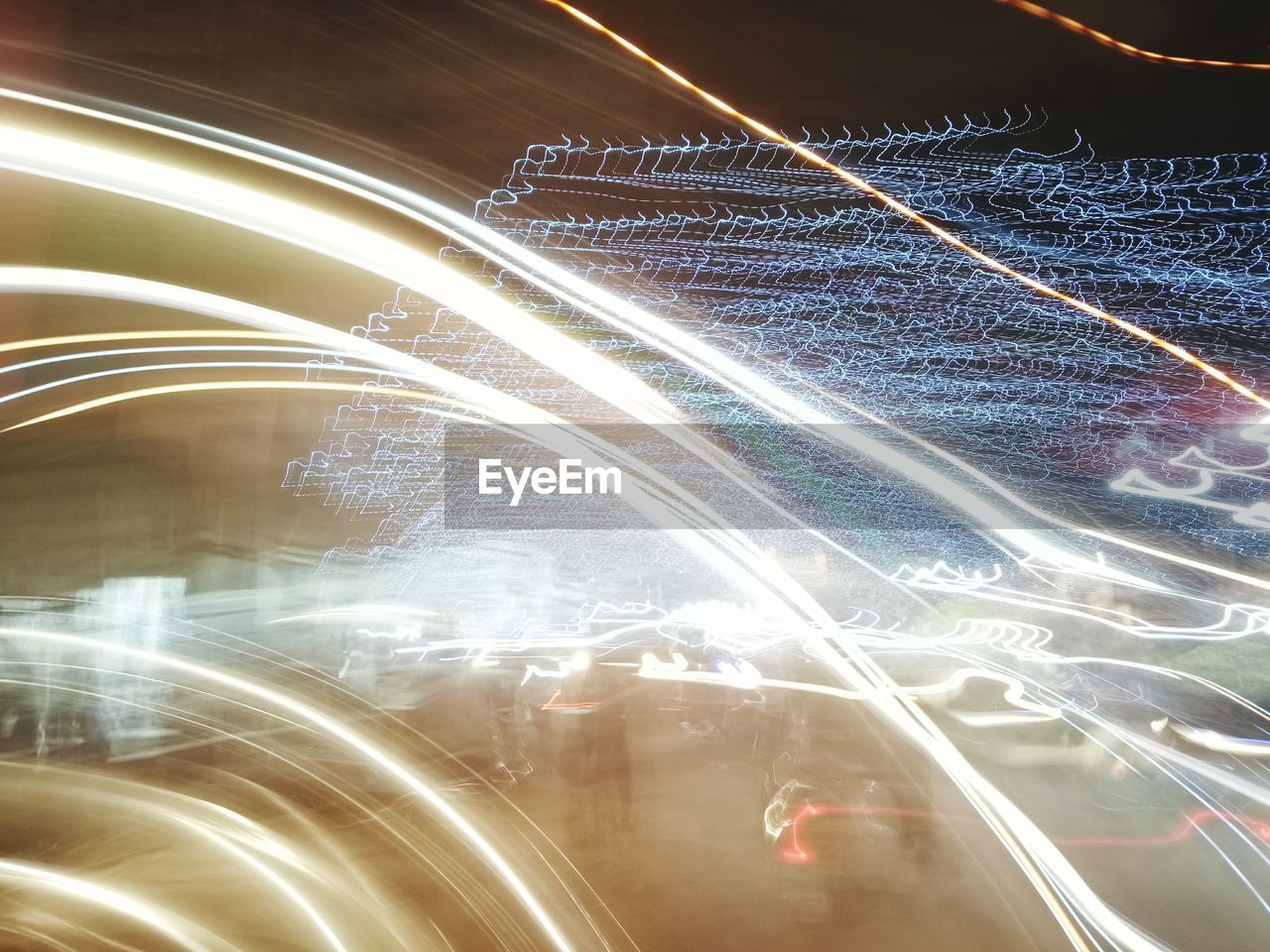 CLOSE-UP OF LIGHT TRAILS ON ILLUMINATED ROAD