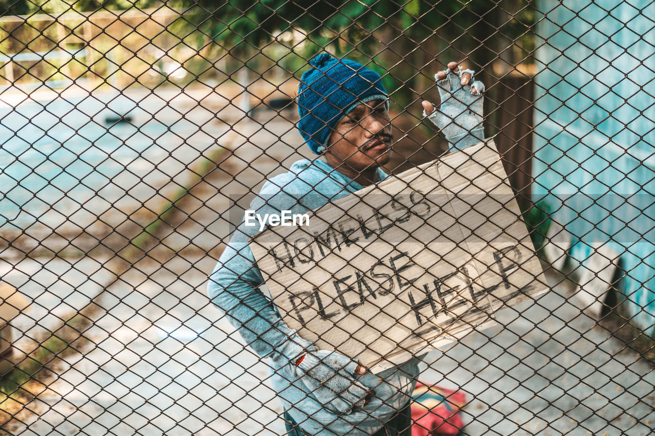 FULL LENGTH OF CHILDREN ON CHAINLINK FENCE BY ROAD