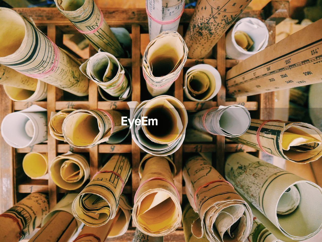 High angle view of rolled up blueprints in rack