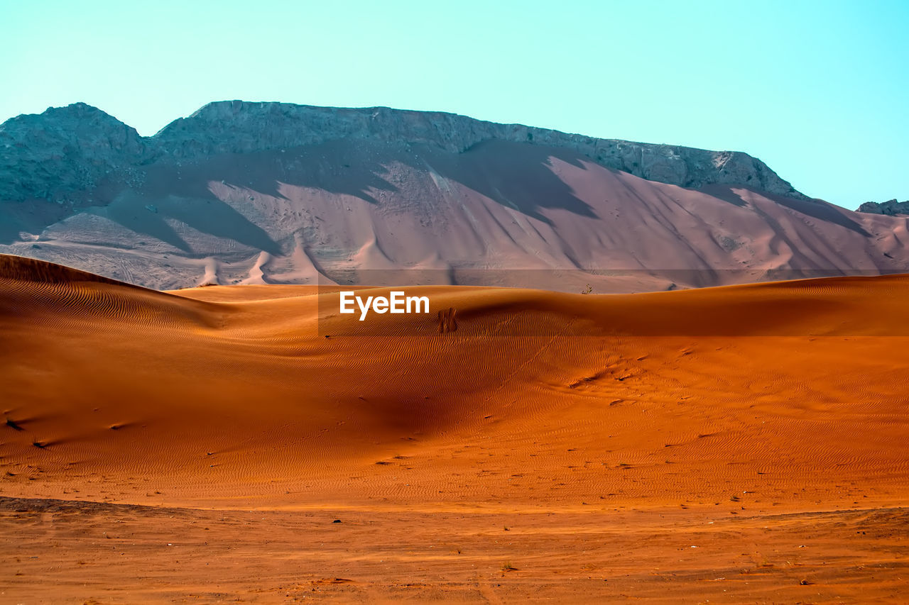 Scenic view of desert and mountains against sky