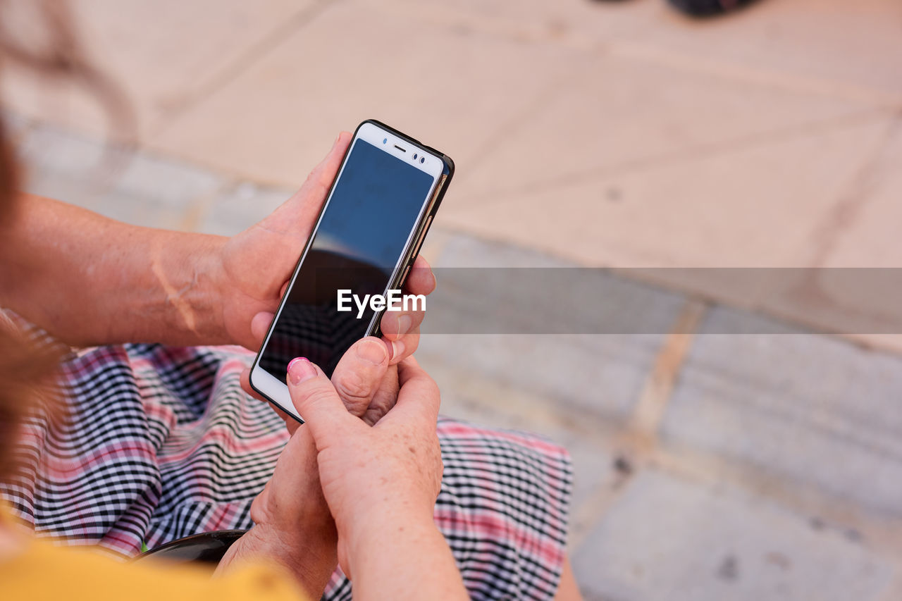 Close up of a middle aged woman and her mother holding a smartphone