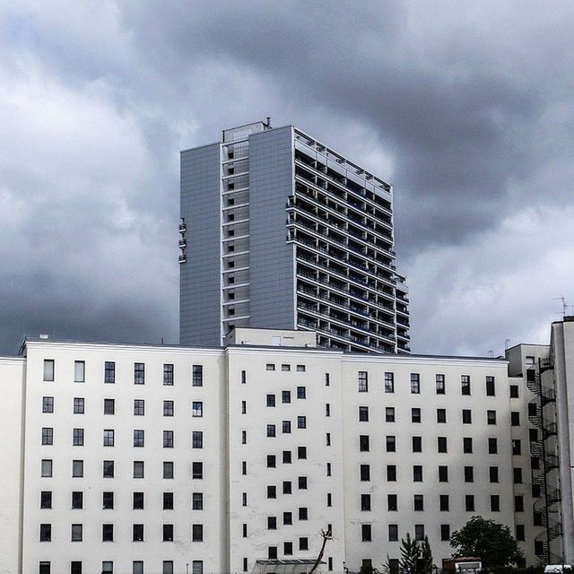 LOW ANGLE VIEW OF MODERN BUILDINGS AGAINST CLOUDY SKY